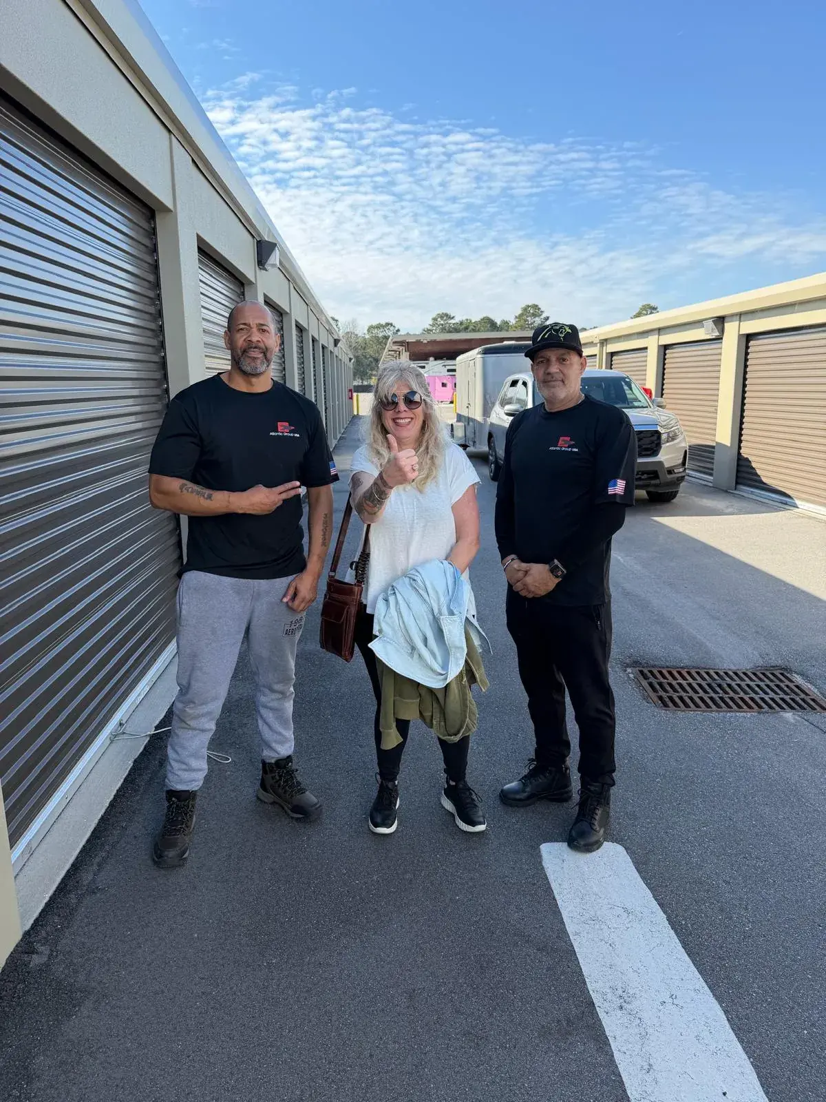 Atlantic Group USA movers in company shirts with a customer at a storage facility
