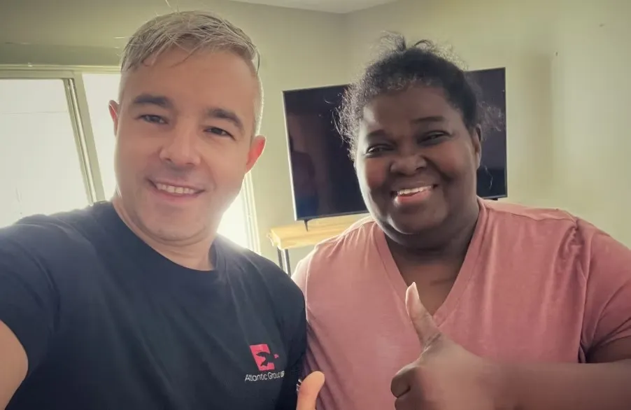Atlantic Group USA mover in company t-shirt taking a photo with a happy customer