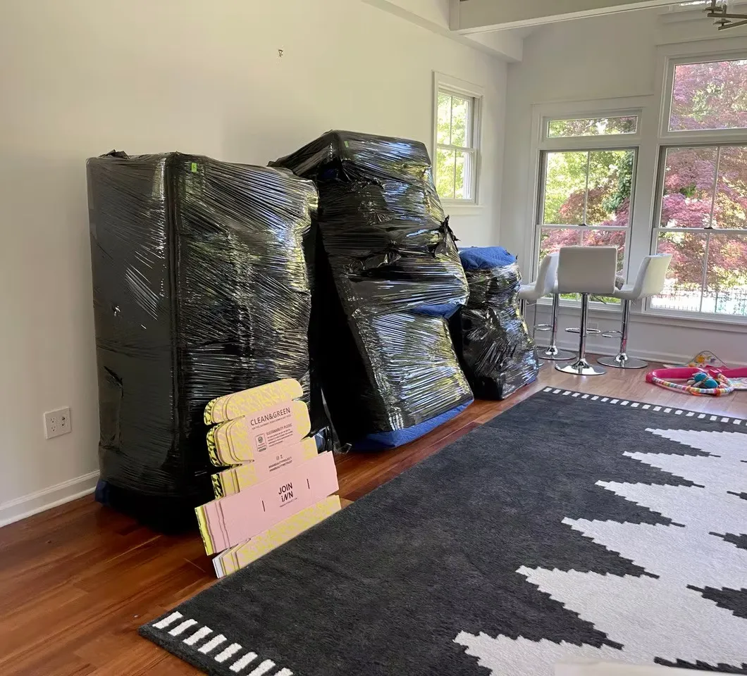 Furniture wrapped in black stretch film ready for loading