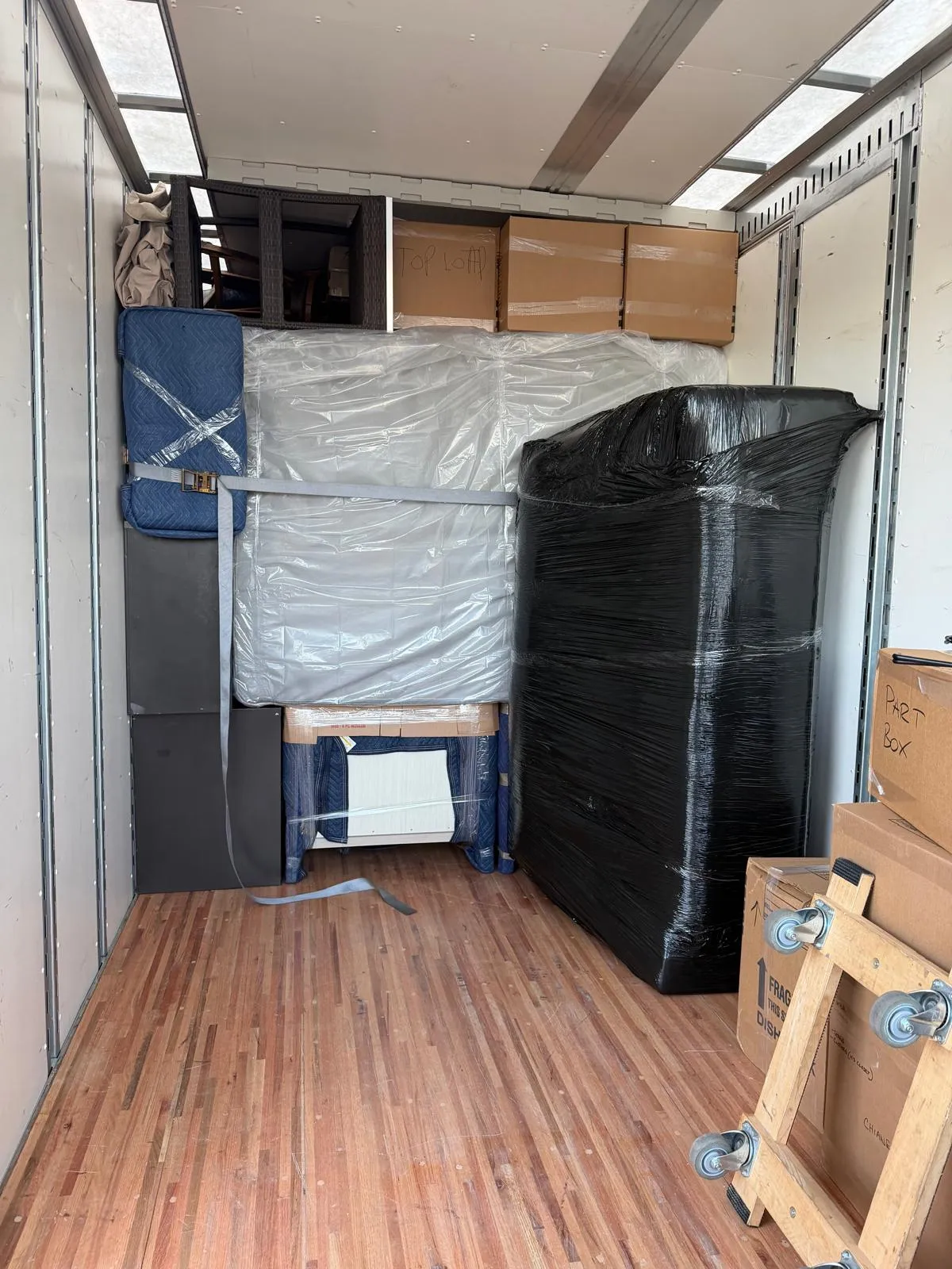 Furniture wrapped in moving pads and stretch film, loaded inside the truck